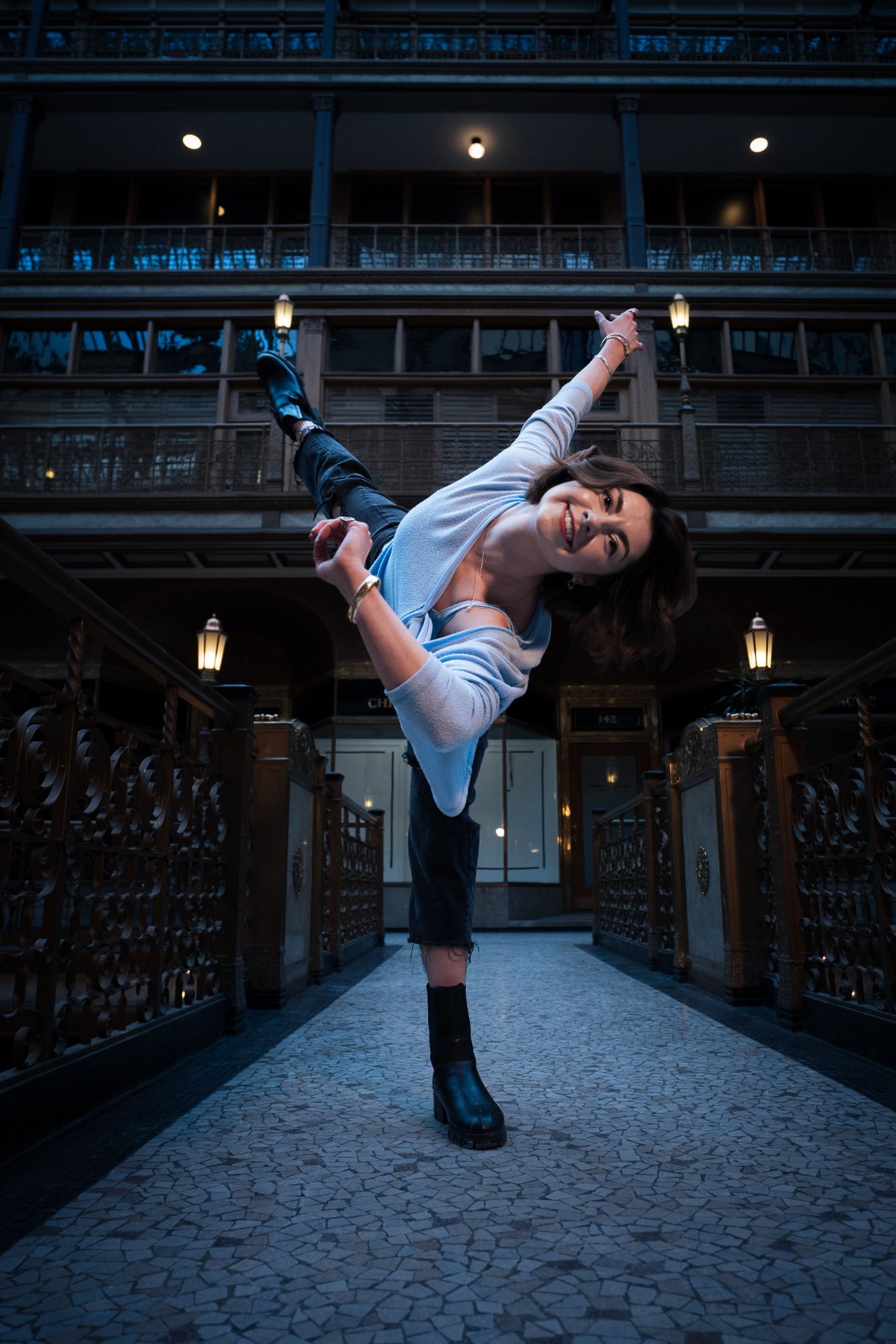 Kate Berk in blue sweater doing high kick